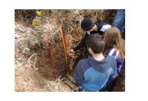 Teenagers looking at soil.