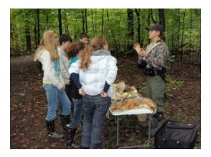 Juveniles listening to an environmentalist in the forest.