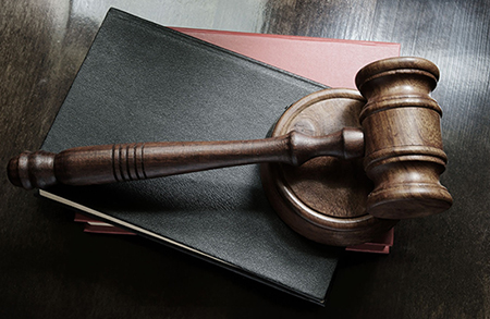 Photo of gavel laying on law books.