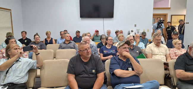 Group of people sitting on chairs at first land use meeting.