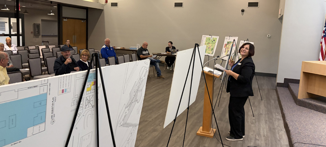 Director Julie Green standing at podium to speak at Southeast Quadrant land use meeting.